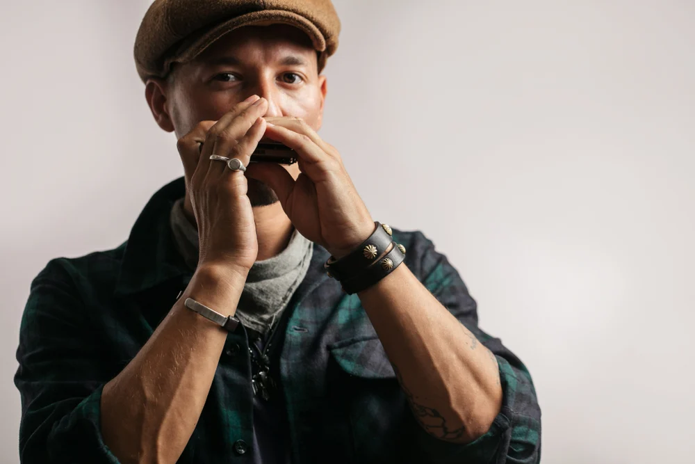 A man focused on learning the harmonica.