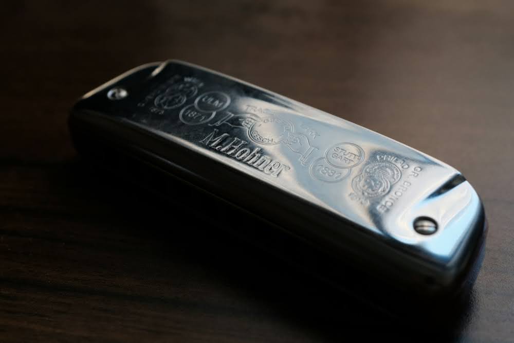 A close-up of a Hohner harmonica lying on the table.