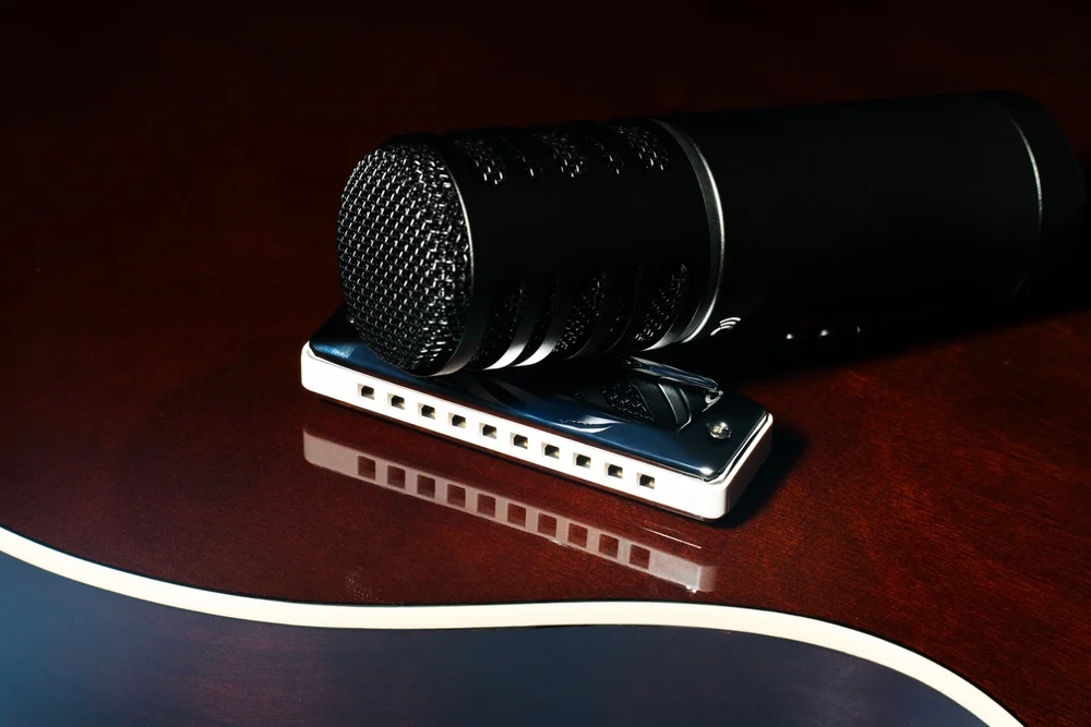 A close-up of a microphone placed on a diatonic harmonica.