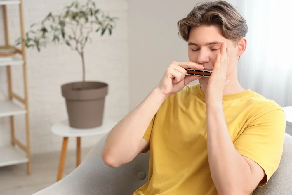 A man working on harmonica techniques.